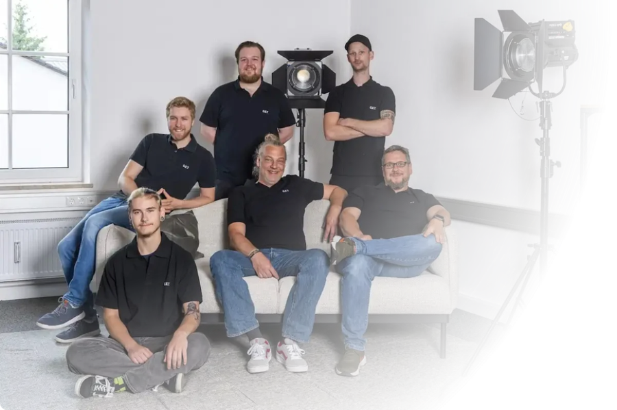 Technikerteam für Eventtechnik München: Crew in Arbeitskleidung vor schwarzem Hintergrund
